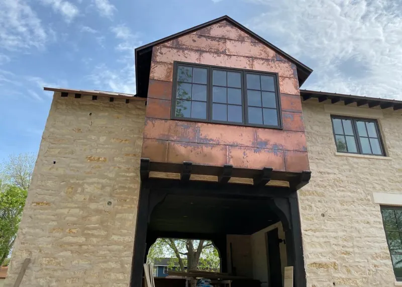 Copper metal panel facade on a stone building for Roof Repair in Gallup